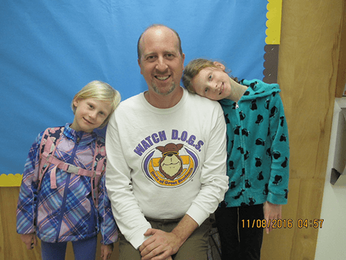 Father reading with elementary students